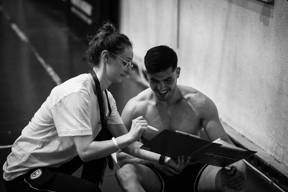 Trainer and client discussing fitness plan in gym. Black and white photo capturing a coaching session.